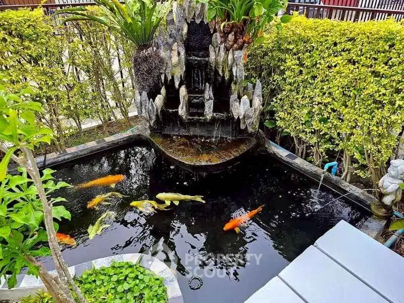 Serene garden pond with colorful koi fish and lush greenery