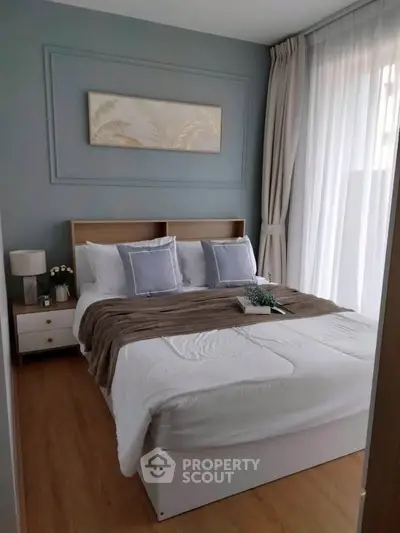 Cozy bedroom with elegant decor and natural light, featuring a comfortable bed and stylish accents.