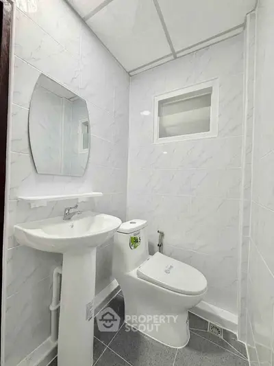 Modern bathroom with sleek white fixtures and elegant tile design.