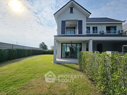 Stunning two-story house with lush green lawn and modern architecture.