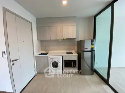 Modern compact kitchen with integrated appliances and sleek cabinetry in a stylish apartment.