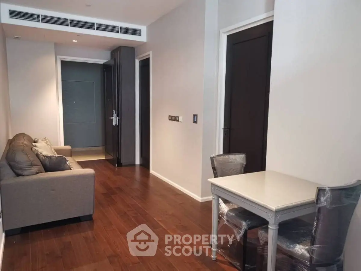 Modern apartment interior with wooden flooring, cozy sofa, and dining area, perfect for urban living.