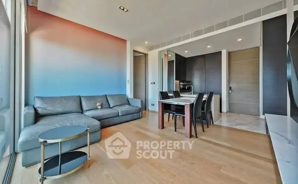 Modern living room with stylish furniture and open layout, featuring a sleek sofa and dining area.