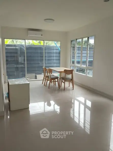Bright dining area with modern furniture and large windows in a contemporary home.