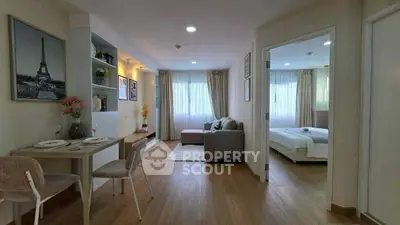 Chic open-plan living room with dining area and cozy bedroom, featuring modern decor and natural light.
