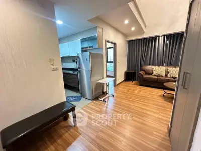 Modern apartment interior with open layout, featuring a cozy living room and sleek kitchen area.