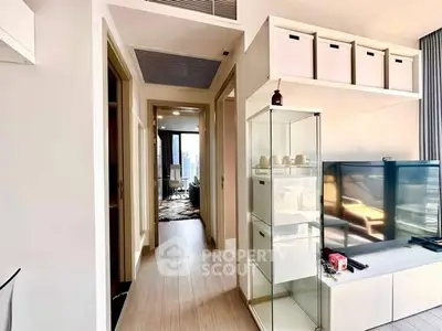Modern apartment interior with hallway and living area, featuring sleek storage solutions.
