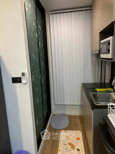 Compact kitchen with modern appliances and vertical blinds