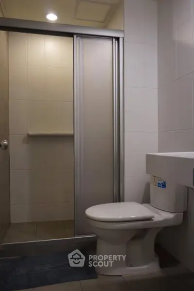 Modern bathroom with sleek shower and toilet in a contemporary apartment.