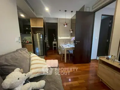 Cozy living room with plush sofa and modern dining area in open layout apartment.