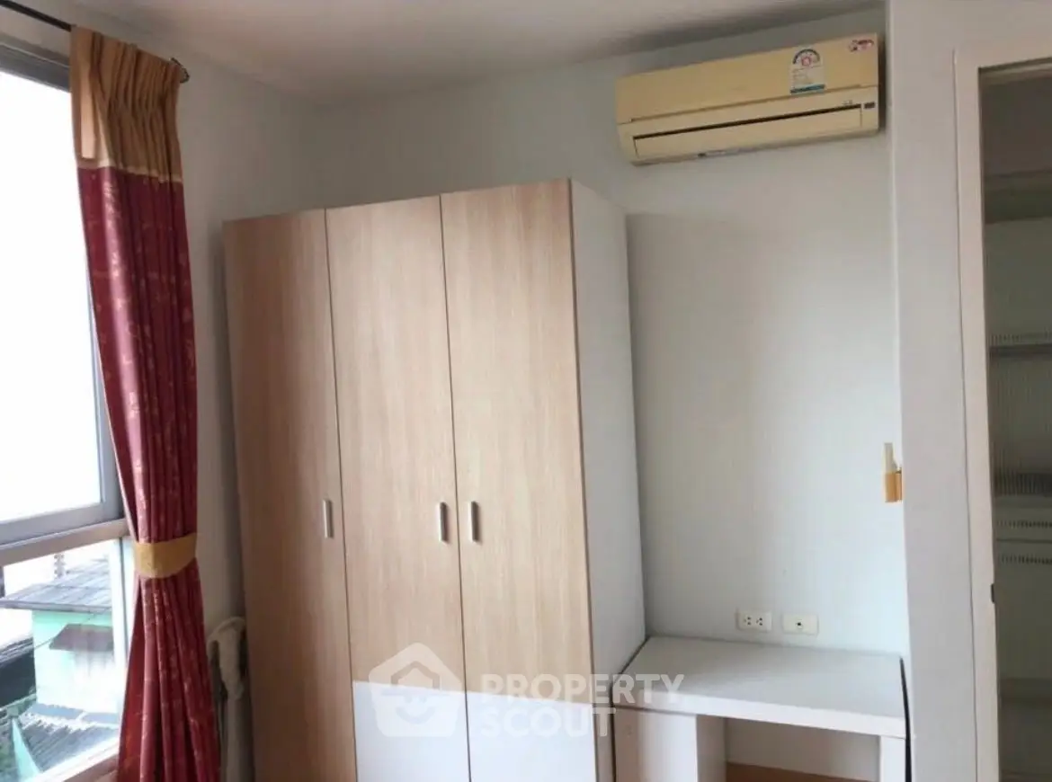 Cozy bedroom with wardrobe and air conditioning unit, perfect for comfortable living.
