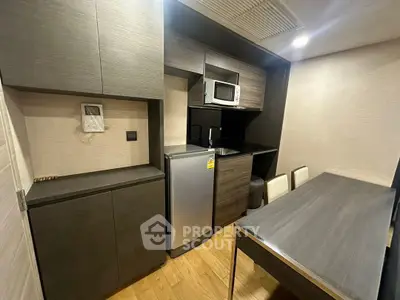 Modern compact kitchen with sleek cabinetry and dining area in urban apartment