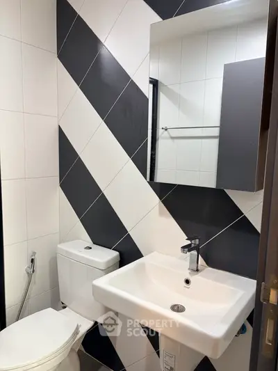 Modern bathroom with stylish black and white tile design and sleek fixtures.