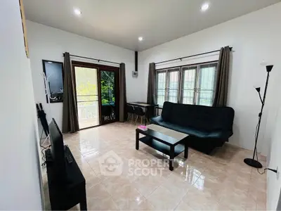 Spacious living room with modern furnishings and large windows offering natural light.