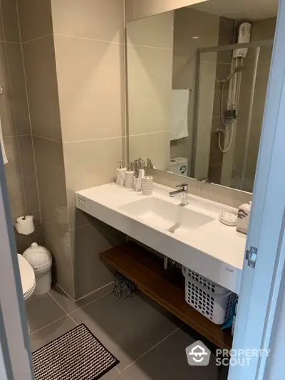 Modern bathroom with sleek design and spacious vanity in contemporary apartment.