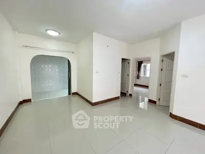 Spacious empty apartment interior with tiled floors and multiple doorways