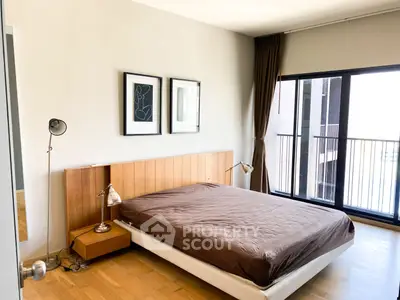 Modern bedroom with large window and minimalist decor in urban apartment