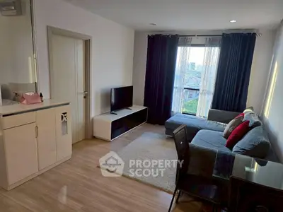 Modern living room with sleek furniture and large window offering city view