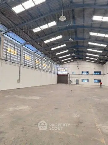 Spacious industrial warehouse with high ceilings and ample natural light.