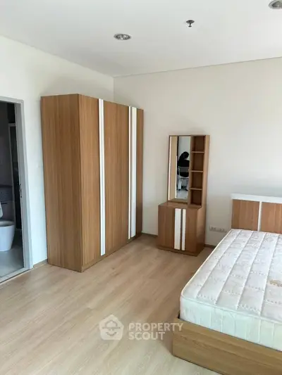 Spacious bedroom with modern wooden furniture and natural light