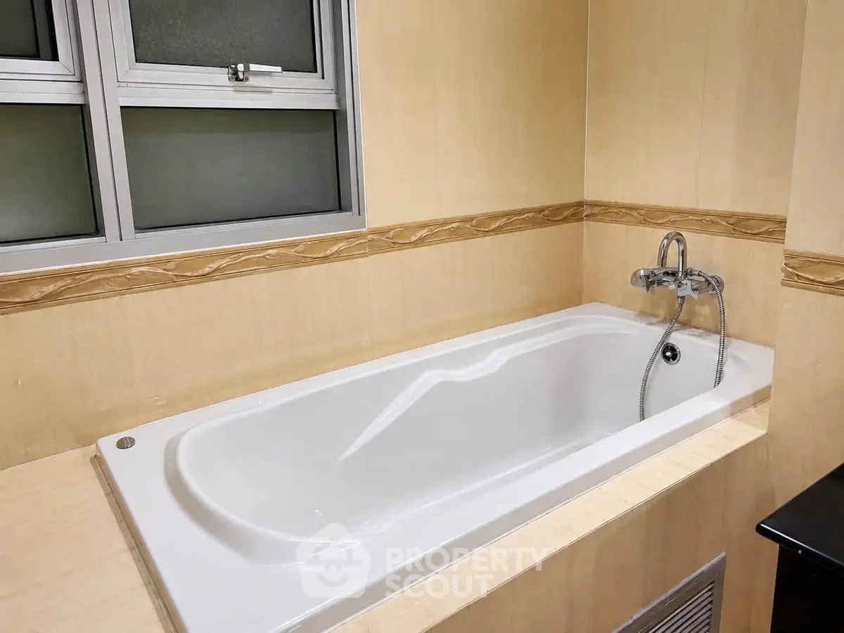 Spacious bathroom with elegant bathtub and modern fixtures, perfect for relaxation.
