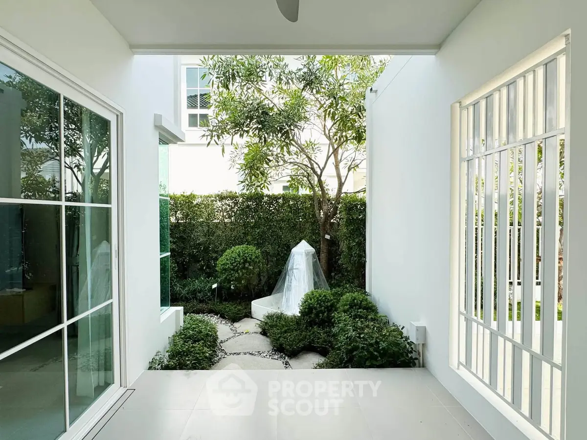 Charming garden view from a modern patio with lush greenery and elegant design.