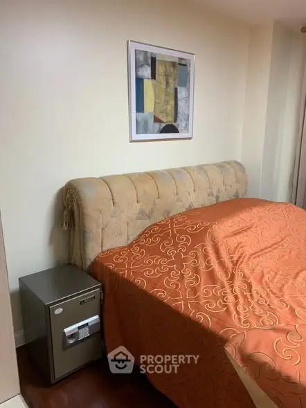 Cozy bedroom with elegant headboard and vibrant orange bedding