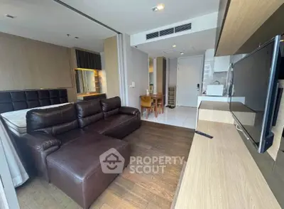 Modern living room with leather sofa and open kitchen in stylish apartment