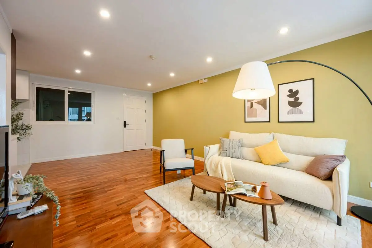 Spacious living room with modern decor and hardwood floors, perfect for relaxation and entertaining.