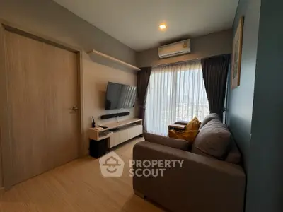 Cozy living room with modern furnishings, wooden flooring, and ample natural light filtering through sheer curtains, perfect for relaxation.