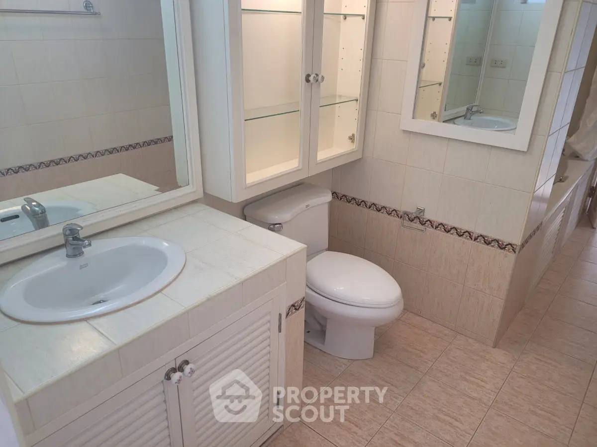 Spacious bathroom with elegant fixtures and ample storage in a modern home.