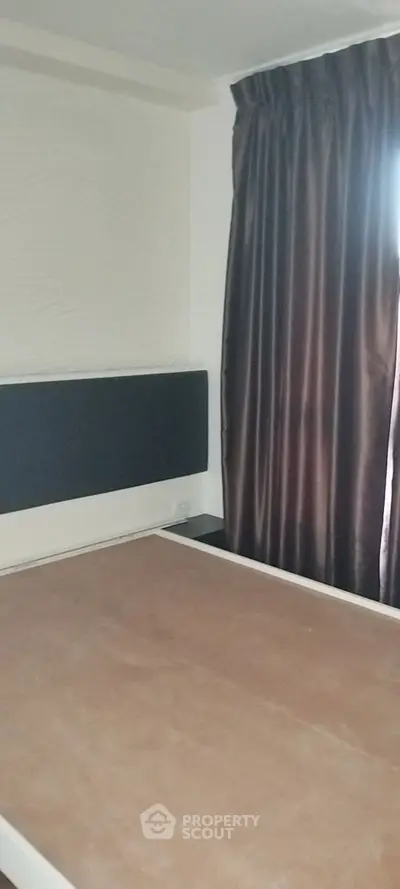 Cozy bedroom with elegant dark curtains and minimalist design, perfect for a restful retreat.