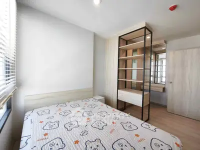 Modern bedroom with stylish shelving and cozy bedding in bright apartment