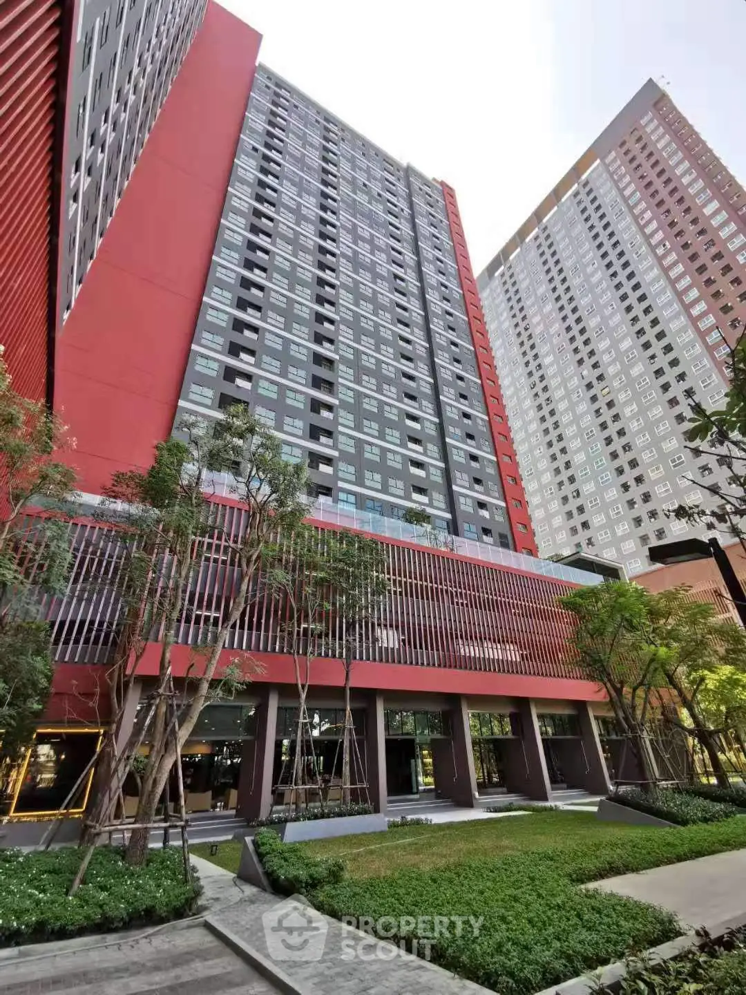 Modern high-rise residential building with lush green landscaping