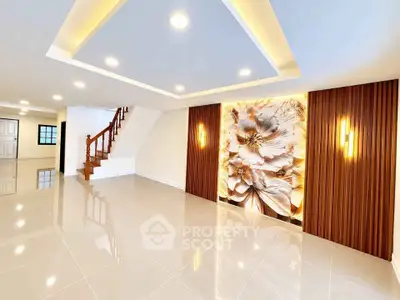 Spacious modern living room with elegant lighting and floral accent wall