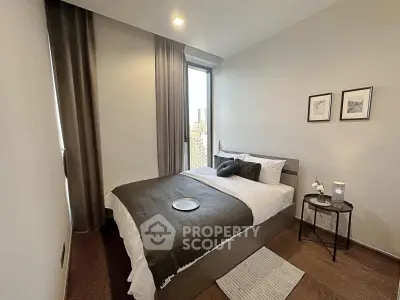 Modern bedroom with city view, featuring elegant decor and cozy ambiance.