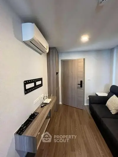 Modern living room with sleek wooden flooring and air conditioning unit