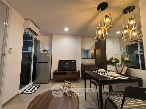 Modern living room with stylish decor and dining area, featuring elegant lighting and sleek furniture.