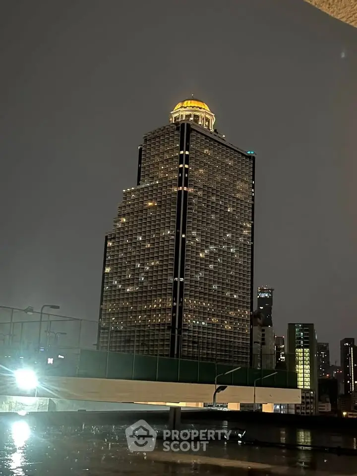 Stunning night view of a modern high-rise building with illuminated dome, showcasing urban architectural elegance.