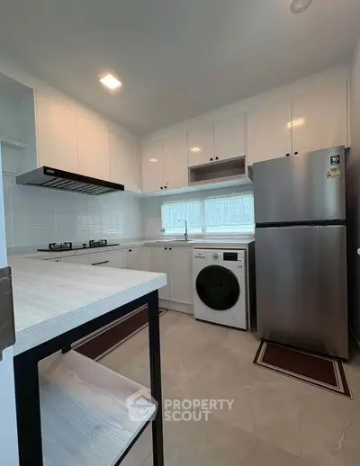 Modern kitchen with sleek appliances and ample storage in a stylish real estate property.