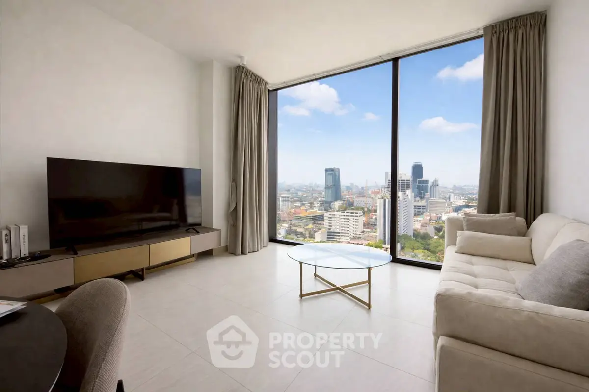 Modern living room with floor-to-ceiling windows offering stunning city views, featuring a sleek TV setup and elegant furnishings.