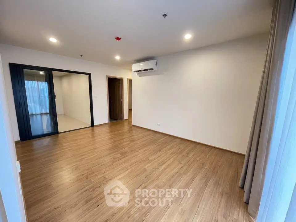 Spacious modern living room with wooden flooring and air conditioning