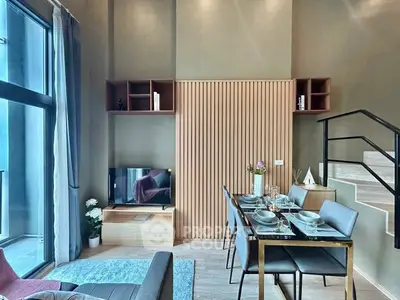 Modern living room with dining area and stylish decor in a contemporary apartment.