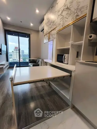 Modern apartment interior with foldable dining table and city view from large window.