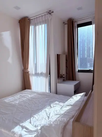 Bright and cozy bedroom with large windows and modern decor.