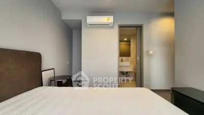 Modern bedroom with ensuite bathroom and air conditioning in a stylish apartment.