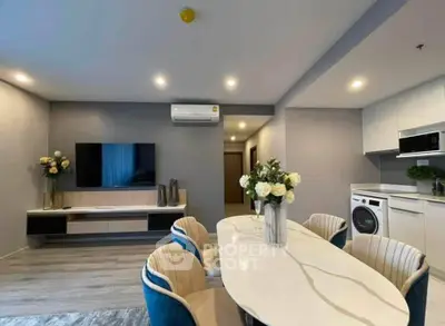 Modern living room with stylish dining area and integrated kitchen appliances in a contemporary apartment.