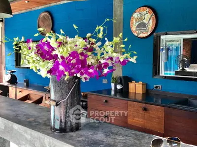 Charming kitchen with vibrant blue walls and elegant floral centerpiece, featuring rustic wooden cabinetry.