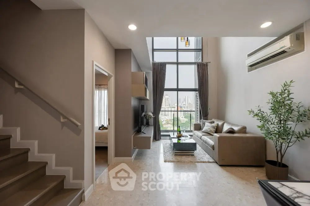 Luxurious modern living room with high ceilings and city view, featuring elegant decor and ample natural light.