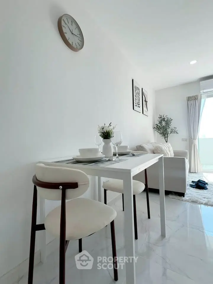 Modern living room with dining area, white decor, and natural light in a stylish apartment.